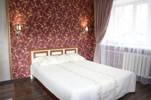 a bedroom with a bed and a red wall at Шикарный ВИП в самом центре Караганды по улице Ерубаева in Karagandy