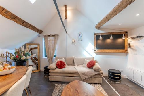 a living room with a couch and a table at L'authentique, Chic, relaxant et entrée autonome in Coulommiers