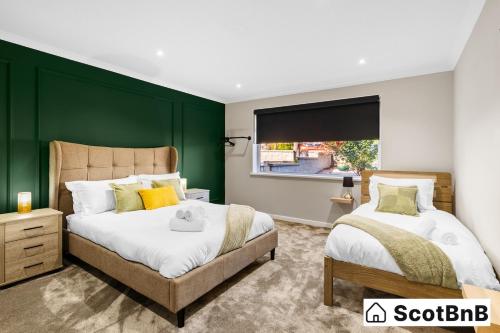two beds in a bedroom with a green wall at Contractor Housing - Parking - Long Stay Discounts in Aberdeen