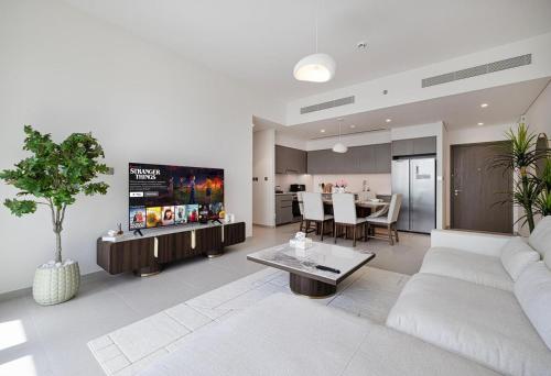 a living room with a white couch and a kitchen at Luxury 2BR Sea Burj views Khalifa infinity pool in Dubai