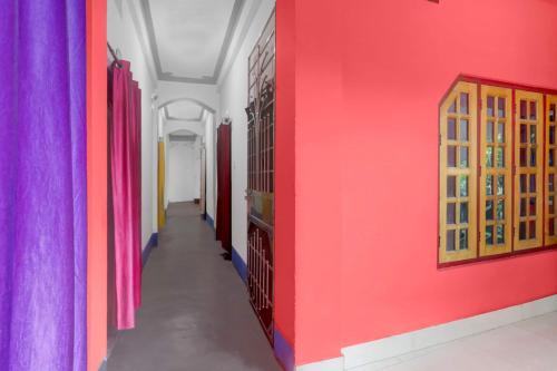 a corridor of a room with pink and colorful walls at Hotel O Trinayani Homestay in Mādāri Hāt