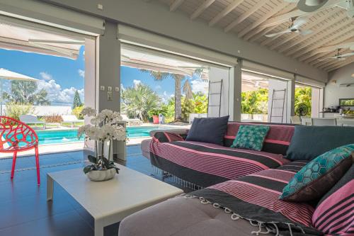a living room with couches and a pool at Villa Azur in Saint-François