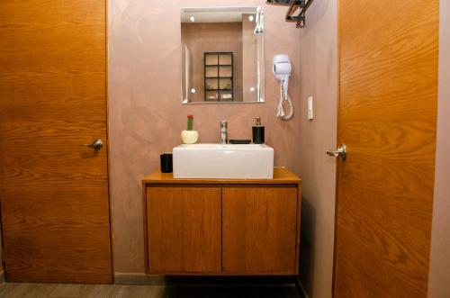 a bathroom with a sink and a mirror at Cozy Apartment in Chapultepec with Gym, Rooftop & Parking in Guadalajara
