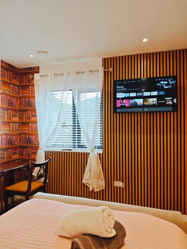 a bedroom with a bed and a television on a wall at Galway Paradisus in Galway