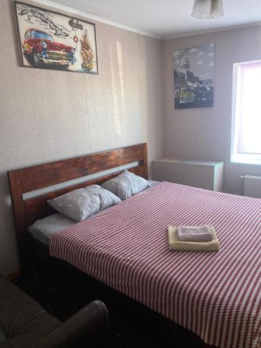 a bedroom with a bed with a red and white blanket at Шервуд in Zhytomyr