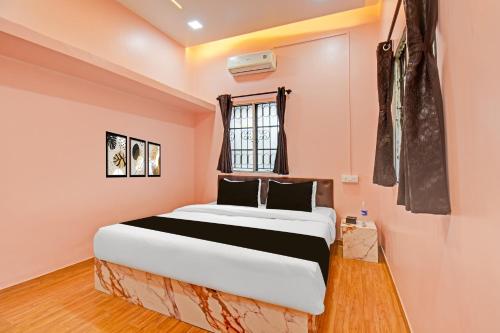 a bedroom with a bed in a pink room at Hotel O The Heaven in Pune