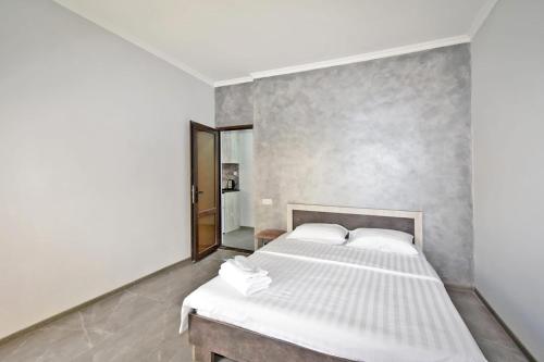 Un dormitorio con una cama blanca y un espejo. en Skyway hotel, en Ereván