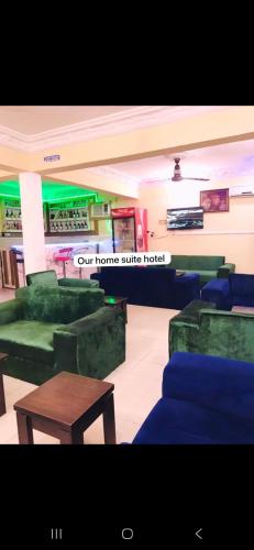 a room with green and blue couches and a table at homesuite in Hausa