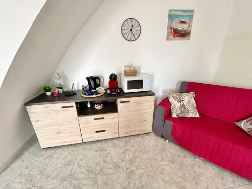 a living room with a red couch and a microwave at Podere 48 - Relax tra mare e natura a Sabaudia - fino a 5 persone in San Donato