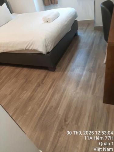 a bedroom with a bed and a wooden floor at Khap Khap Thai Res Hotel 4 in Ho Chi Minh City
