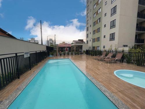 a swimming pool in the middle of a building at Apto completo, Piscina, Cinema, Home Clube e Jardim in Piçarras