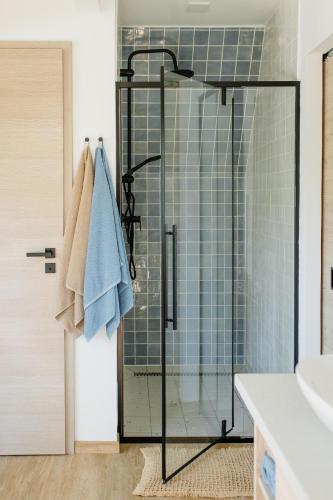 a shower with a glass door in a bathroom at A Hely Ahol in Nagymaros