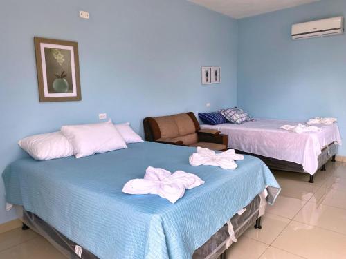 two beds in a room with blue walls at Habitación El Paredon in El Paredón Buena Vista