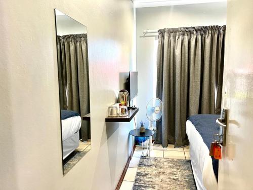 a small room with two beds and a mirror at De'Lush Oasis in Pretoria