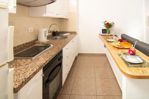 a kitchen with a sink and a counter with fruit on it at Le Petit Paradise in Playa de las Americas