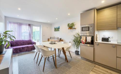 a kitchen and living room with a table and chairs at Luxurious 3BD Town house with garden in Hackbridge