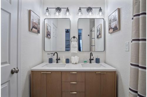 un baño con dos lavabos y dos espejos en Comfy and Happy Stays Near Riverwalk and Downtown, en San Antonio