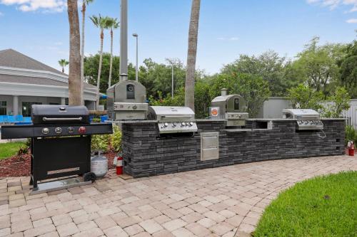 a barbecue grill in a brick wall in a yard at Family 1BR 2 Queen Beds Sofa Orlando in Orlando