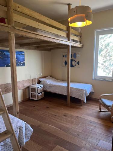a bedroom with two beds and a loft bed at Humus Sapiens 2 in Tavarone