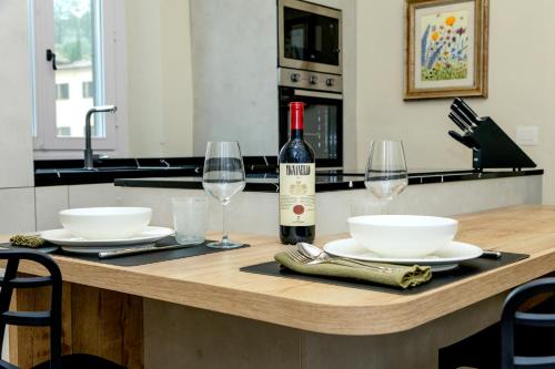 a table with a bottle of wine and two glasses at Stay in Chianti in Greve in Chianti