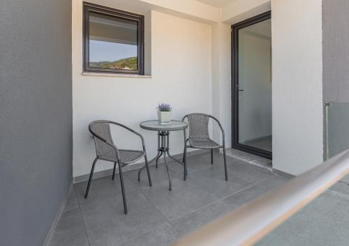 a table and chairs in a room with a window at arvangroup-apartments in Nafpaktos