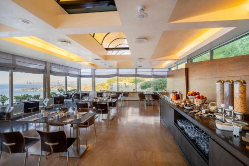 a restaurant with tables and chairs and large windows at Eurostars Monte Tauro in Taormina
