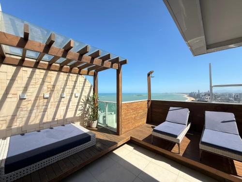 a balcony with two chairs and a view of the ocean at Cobertura dúplex frente mar in Vila Velha