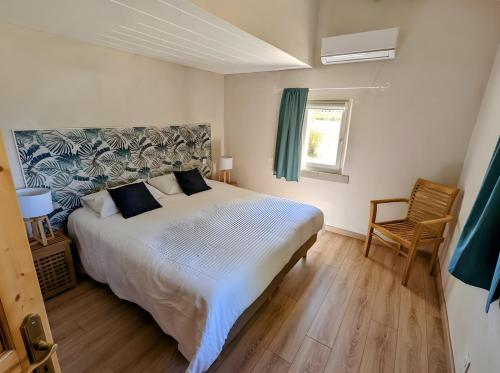 a bedroom with a large bed and a chair at Le Ventoux in Tulette