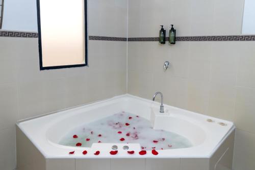 a white bath tub with red hearts in it at Hotel Plaza Monte Carlo in Guayaquil