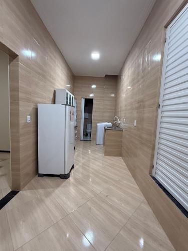 a kitchen with a white refrigerator in a room at Garrida in Itarema