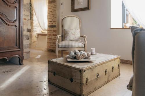 a living room with a chair and an old trunk at Campagne Médicis Piscine, jacuzzi & sauna privés in Juré