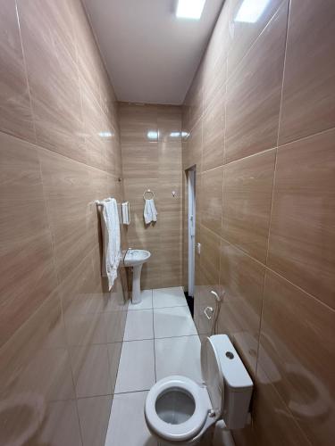 a bathroom with a toilet and a sink at Garrida in Itarema