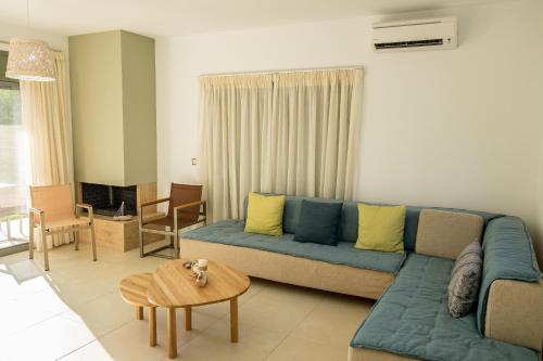 a living room with a blue couch and a table at Ionian Green Villas in Preveza