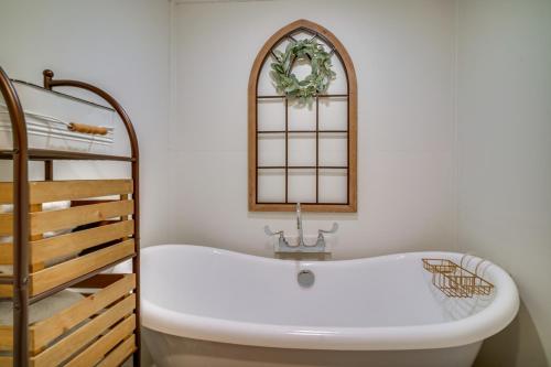 Una bañera en un baño al lado de una escalera. en Cozy Couples Retreat with Porch on Bayou Teche!, en New Iberia