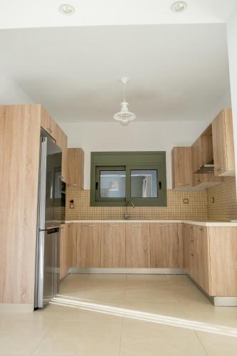 a kitchen with wooden cabinets and a window at Ionian Green Villas in Preveza