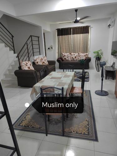 a living room with a table and chairs at Homestay Qaseh Ibu sungai petani in Sungai Petani