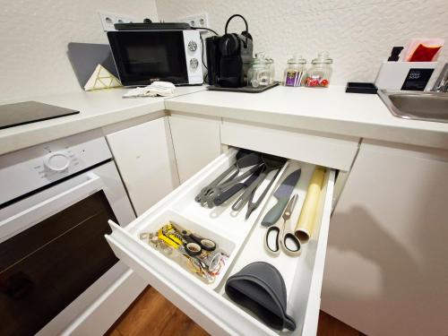 an open kitchen drawer with scissors and other tools at Central Station Lux Downtown Apartman in Budapest