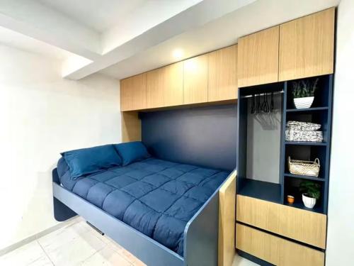 Un dormitorio con una cama azul en una habitación. en Living Alameda, en Querétaro