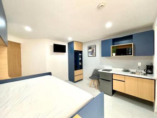 Un dormitorio con una cama y una cocina con fregadero. en Living Alameda, en Querétaro