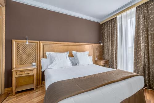 a bedroom with a large bed and a window at Exe Doña Carlota in Ciudad Real