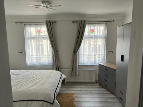 a bedroom with two windows and a bed and a dresser at Favourland Home in Moffat