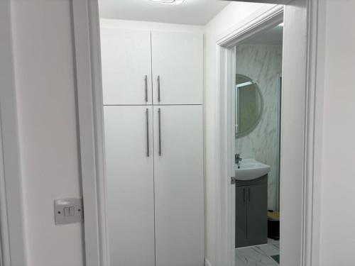 a bathroom with a white cabinet and a mirror at Favourland Home in Moffat