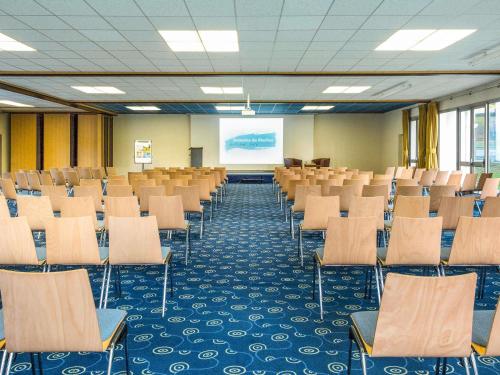 an empty room with chairs and a projection screen at Mercure Aix-les-Bains Domaine de Marlioz Hôtel & Spa in Aix-les-Bains