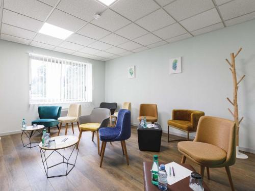a waiting room with colorful chairs and tables at Mercure Aix-les-Bains Domaine de Marlioz Hôtel & Spa in Aix-les-Bains