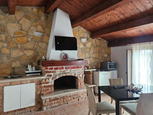 a living room with a stone wall with a fireplace at L'antico Orologio in Isola Capo Rizzuto