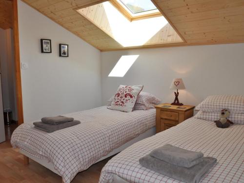 two twin beds in a room with a skylight at Appartement spacieux près des pistes avec balcon et parking - FR-1-692-14 in La Chapelle-dʼAbondance
