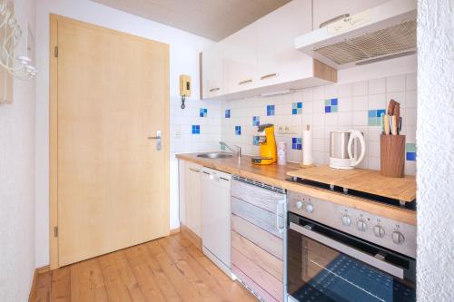 a kitchen with a sink and a stove top oven at Alpenflora Ferienwohnungen in Ofterschwang