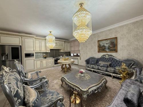 Una sala de estar con sofás y una lámpara de araña. en Khatai Vip Apartment 2 bedrooms, en Baku