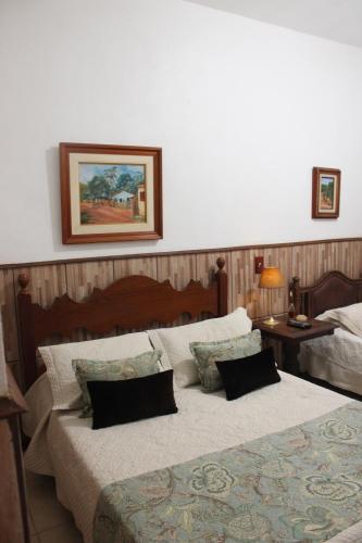 a bedroom with two beds and a picture on the wall at Pousada do Campo in Barra do Piraí