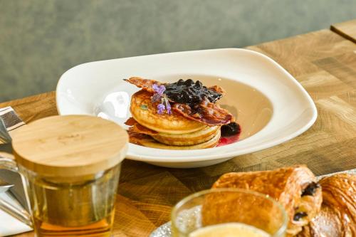 a plate of pancakes on a table with a glass of beer at voco The Hague by IHG in The Hague